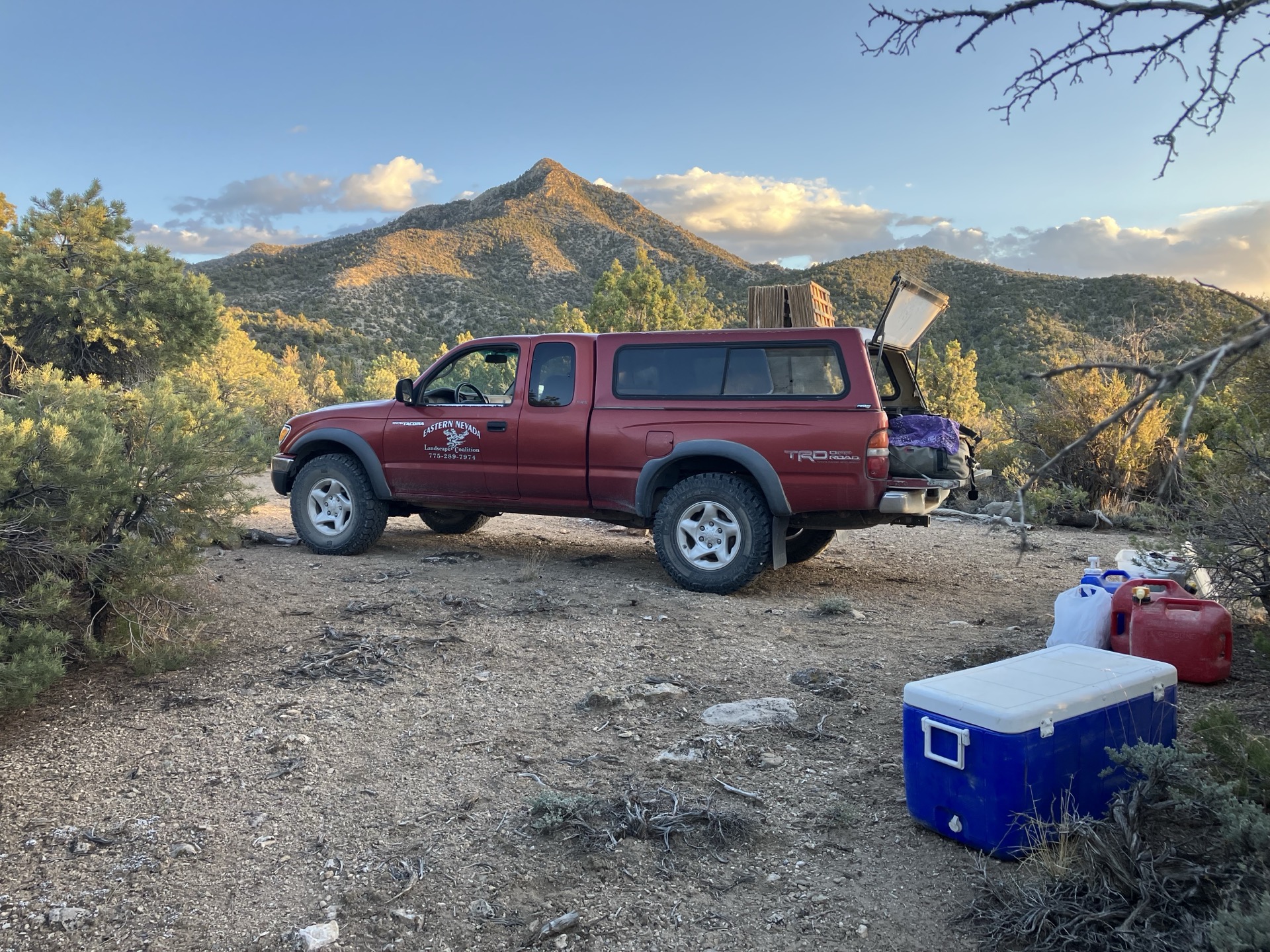An ENLC-branded field truck parked at a Great Basin work site at golden hour, with mountains in the background