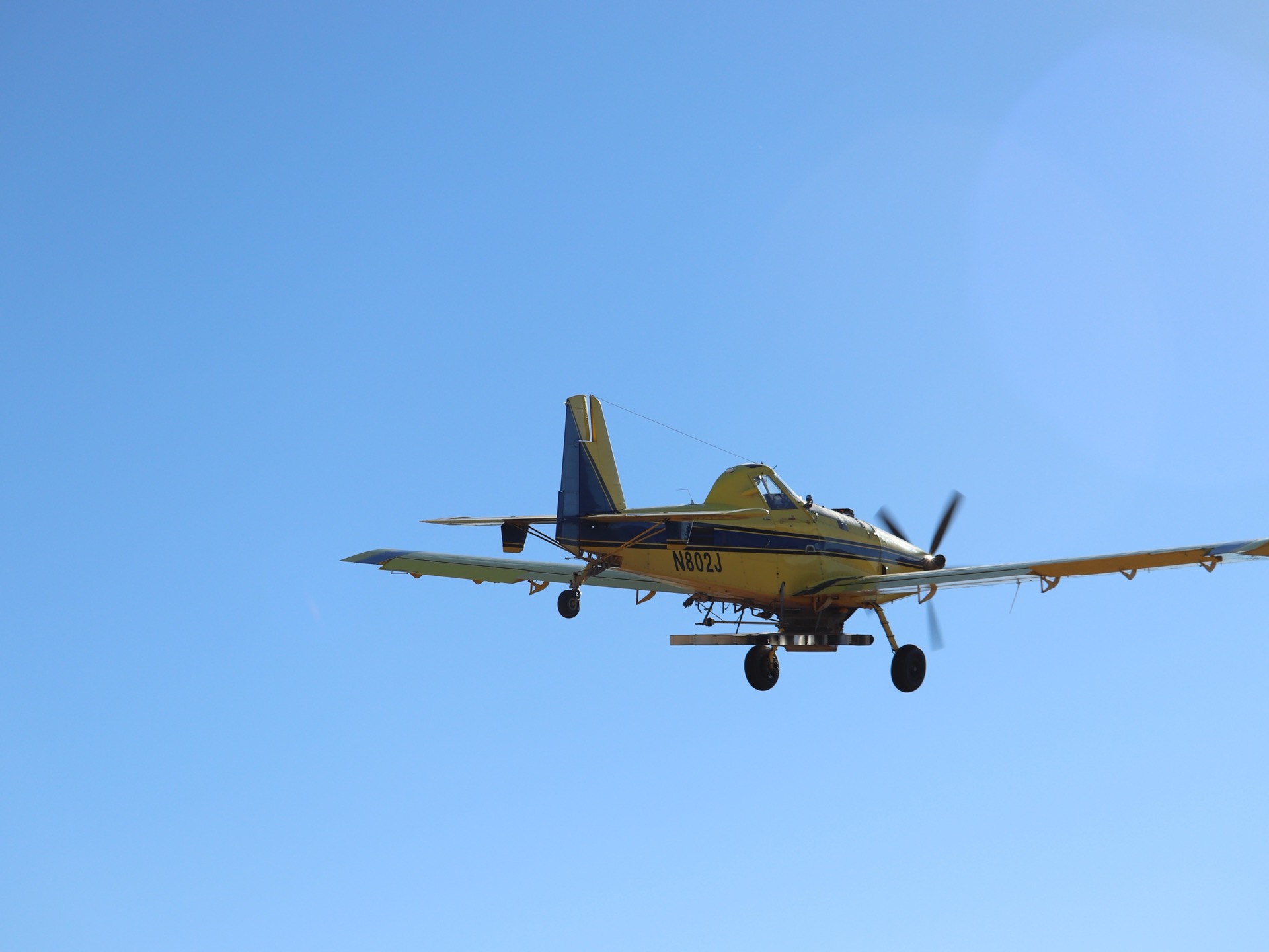 An aerial-seeding aircraft in flight over the Great Basin during a post-fire restoration project